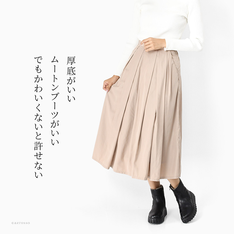 ガボール Gabor の厚底ムートンショートブーツ 黒 を着用した女性コーデ。ベージュのスカートと合わせたきれいめスタイル。内ボア付きの本革ブーツは超軽量で歩きやすく、40代・50代女性にも人気。