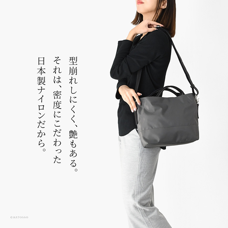 高密度ツイルナイロン使用のきれいめショルダーハンドバッグを肩掛けする女性。マチ広で旅行や日常使いに便利なレディースバッグ