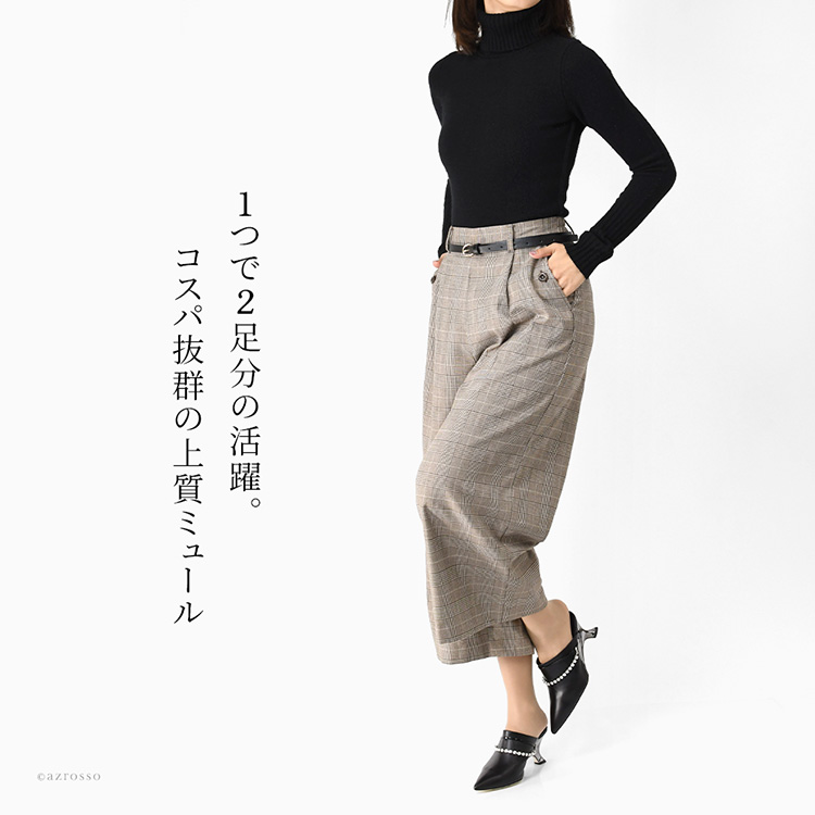 黒のタートルネックニットとチェック柄のワイドパンツを合わせた女性の全身コーディネート。足元には、LIMIT TILL 2359の日本製本革ミュール（ブラック）を着用