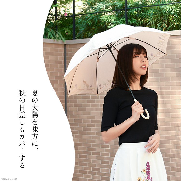 派手すぎない花刺繍が映えるベージュの布製日傘。晴雨兼用・長傘タイプで、夏から秋まで使える軽やかな一本。