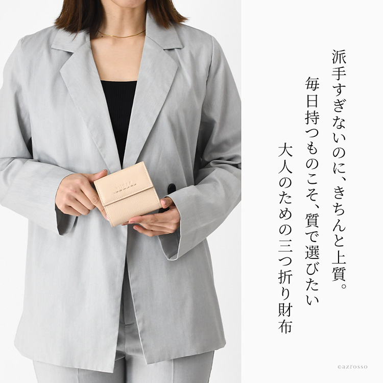 小さめバッグにもすっきり収まるコンパクトなサイズ感。派手すぎずきちんと上質な、イタリアブランド「プリニオ ヴィソナ」の本革三つ折り財布を手に持つ大人の女性