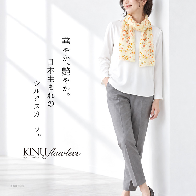小さな花々を散りばめた花柄のシルク100%サテンロングスカーフ（日本製・横浜スカーフ）を首元に巻いた女性モデル