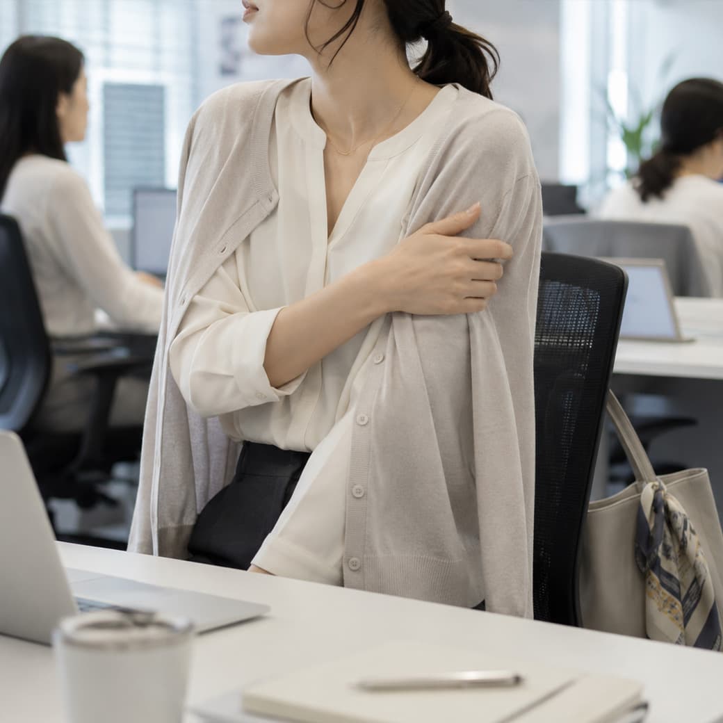 夏の通勤後にオフィスの冷房対策をする女性のイメージ